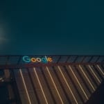 Panneau Google illuminé sur un immeuble moderne au crépuscule, ambiance urbaine.