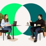 Deux personnes discutent autour de tables, dans un bureau moderne et verdoyant.