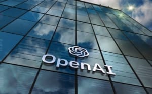 Façade du siège d'OpenAI avec le logo de l'entreprise et un ciel bleu.