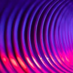 Une vue rapprochée et abstraite de rainures circulaires concentriques dans des tons de violet et de rose vif.