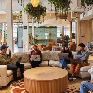 Des collègues travaillent ensemble dans un espace de coworking moderne et verdoyant.