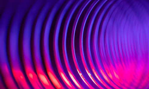 Une vue rapprochée et abstraite de rainures circulaires concentriques dans des tons de violet et de rose vif.
