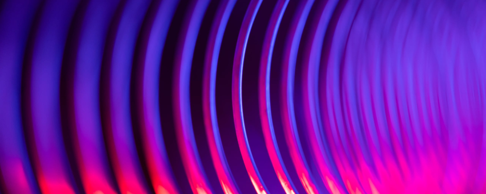 Une vue rapprochée et abstraite de rainures circulaires concentriques dans des tons de violet et de rose vif.