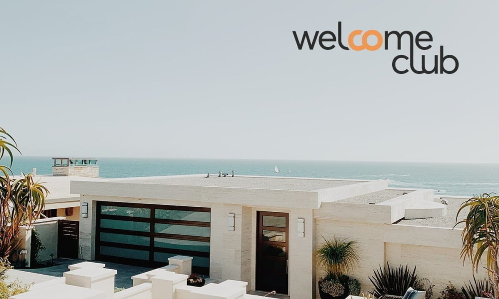 Maison moderne au bord de la mer avec vue sur l'océan et le logo "welcome club".